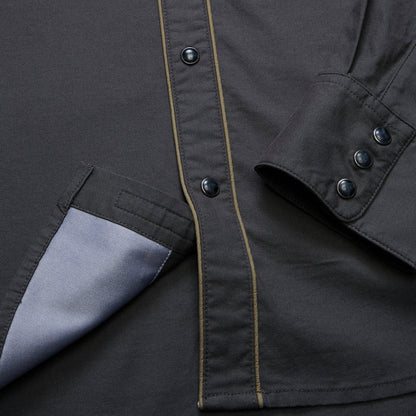 A close-up of the Howler Brothers Broncbuster Longsleeve Snapshirt in MoonlessNight showing the snap buttons and pocket lining.