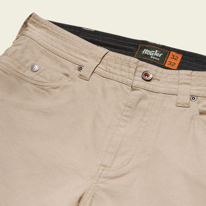 A close-up of the Howler Brothers Frontside 5-Pocket Pants in Faded Khaki showing the waistband and pocket details.