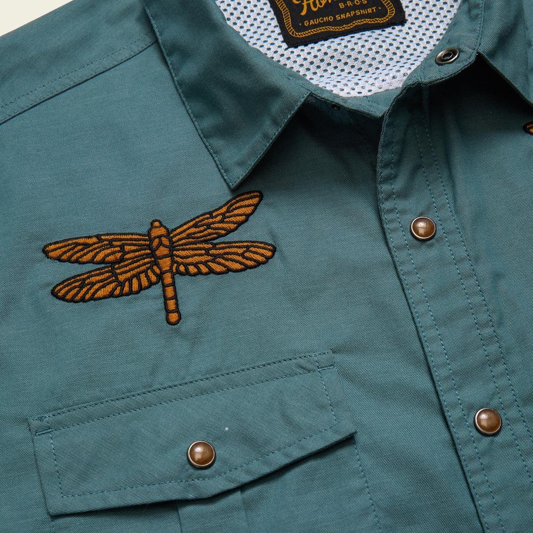 A close up of the Howler Brothers Men's Gaucho Snapshirt in Enter The Dragons showing the dragonfly embroidery on the chest pocket.