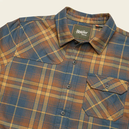 A close-up of the Howler Brothers Men's Harker Flannel in Kempton Plaid : Stargazer showing the chest pocket and button placket against a neutral background.