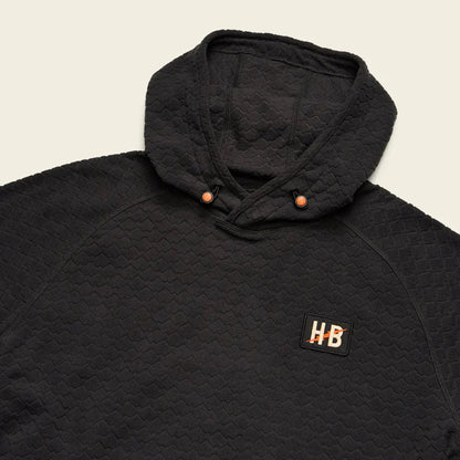 A close-up of the Howler Brothers Men's Palo Duro Fleece Hoodie in Antique Black showing the hood and "HB" patch against a light background.