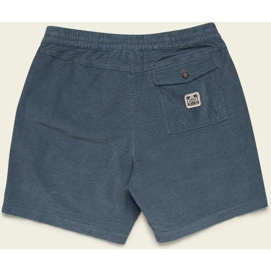 Back view of the Howler Brothers Men's Pressure Drop Cord Shorts in Grid : Blue Mirage showing the back pocket with a logo and elastic waistband against a light background.