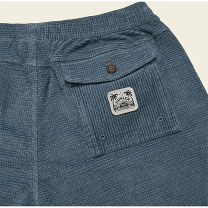 Back pocket of Howler Brothers Men's Pressure Drop Cord Shorts in Grid : Blue Mirage showing the pocket patch and button.