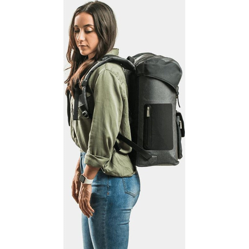 Side view of the IceMule Coolers Urbano 30L in Snow Grey showing the front pocket and model wearing it against a white background.
