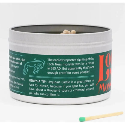 A round white and green Loch Ness Monster scented candle tin with a match in front, showing text about the Loch Ness monster.