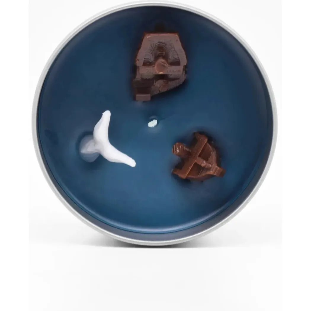 A blue JD and Kate Industries Moby Dick scented candle with a white whale and brown ship pieces inside.