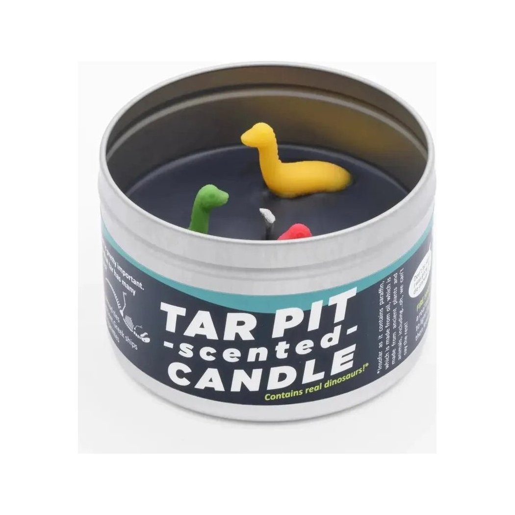 A close up of a JD and Kate Industries Tar Pit Scented Candle tin showing the label and three small dinosaur figurines inside.