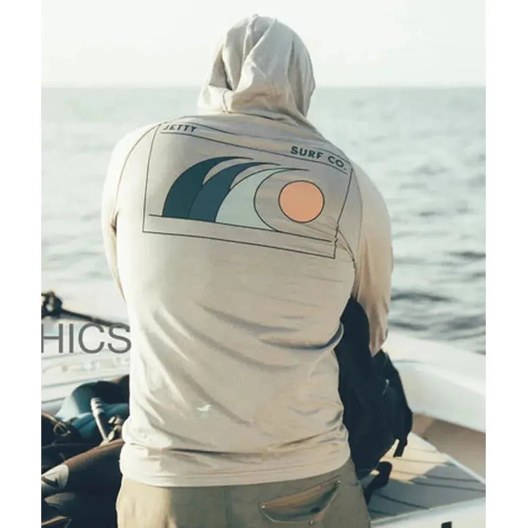 Back view of the Jetty Men's Mahi UV Tech Hoodie in Grey showing the surf graphic on the back while a man stands on a boat by the ocean.