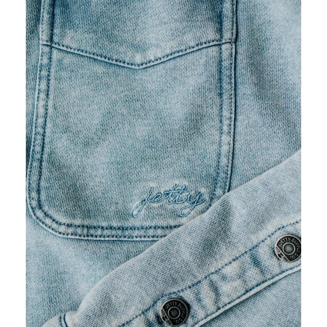 A close-up of the Jetty Women's Eden Knit Shirt in Denim showing the front pocket and button placket.