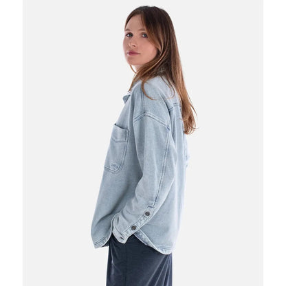 Side view of the Jetty Women's Eden Knit Shirt in Denim showing the front pocket and buttoned cuffs against a white background.