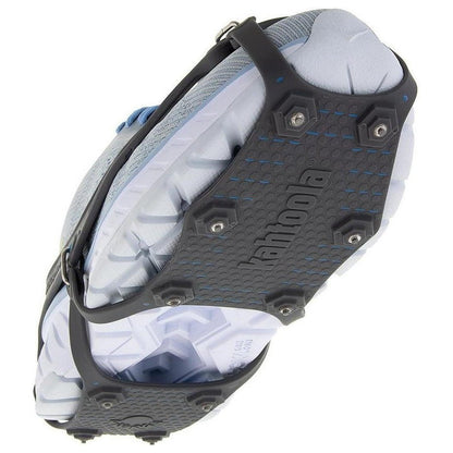 A top-down view of the Kahtoola NANOspikes Footwear Traction in Black, showing the spiked traction plate and attached to a light-colored shoe.
