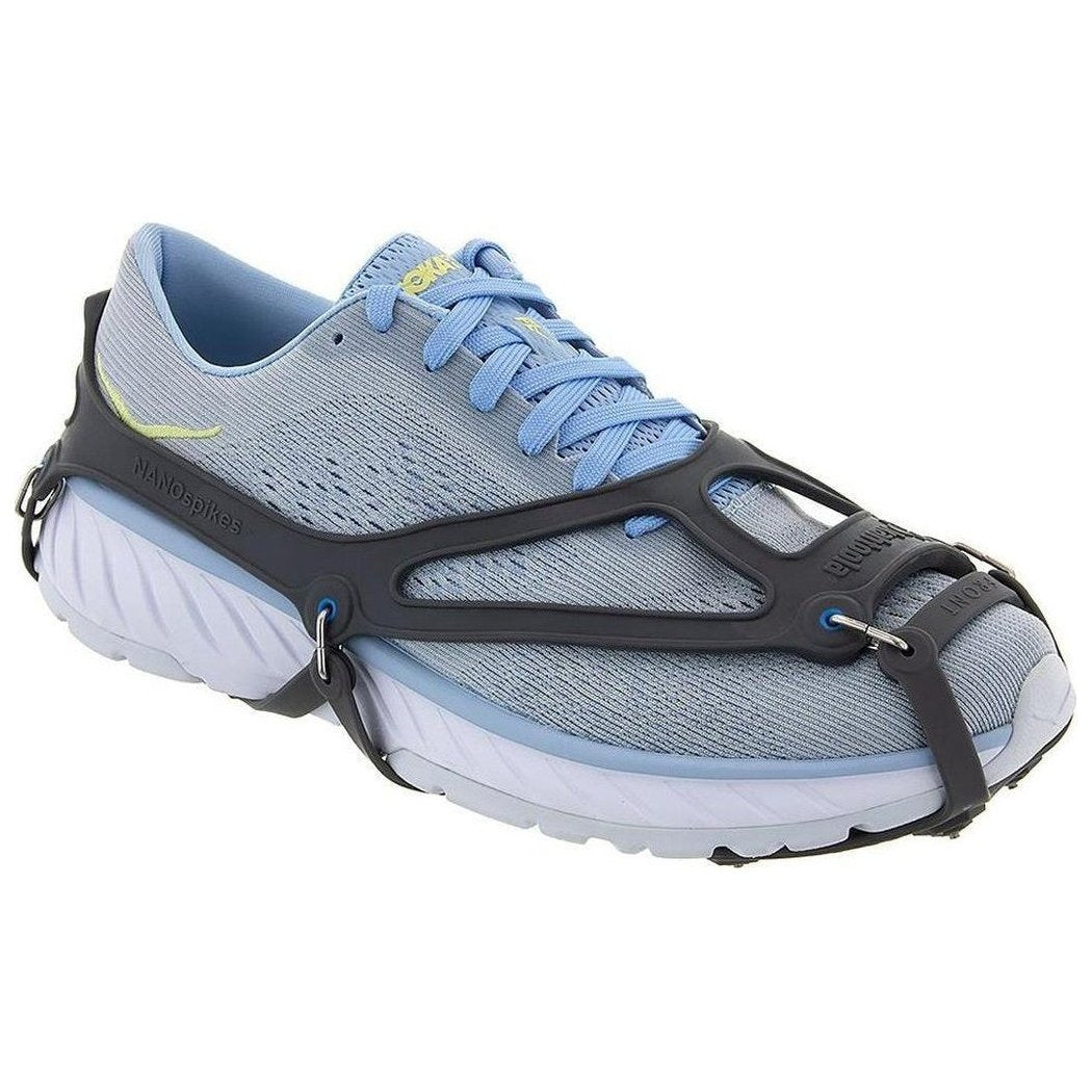 Side view of the Kahtoola NANOspikes Footwear Traction in Black showing the black traction device and light blue sneaker against a white background.