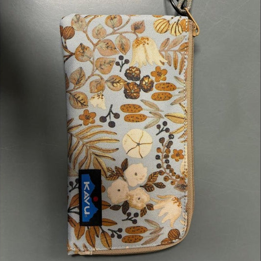 A top-down view of the Kavu Clutch Case in Frosty Foliage with a blue Kavu tag and a black and white tag attached.