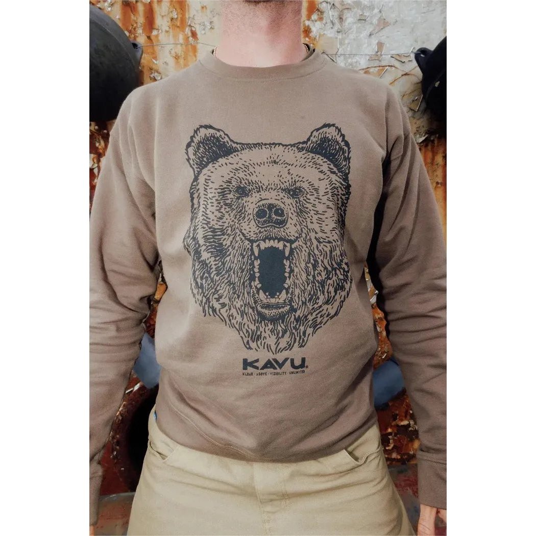 A front view of the Kavu Men's Core Crew Brown Bear sweatshirt on a model with a rusted metal background.