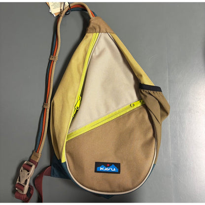 A front view of the Kavu Mini Paxton Pack in Forest Pass showing the yellow zipper and adjustable strap against a gray background.