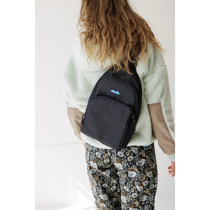 Back view of the Kavu Pender Pack in Frosty Foliage on a model wearing floral pants against a white background.