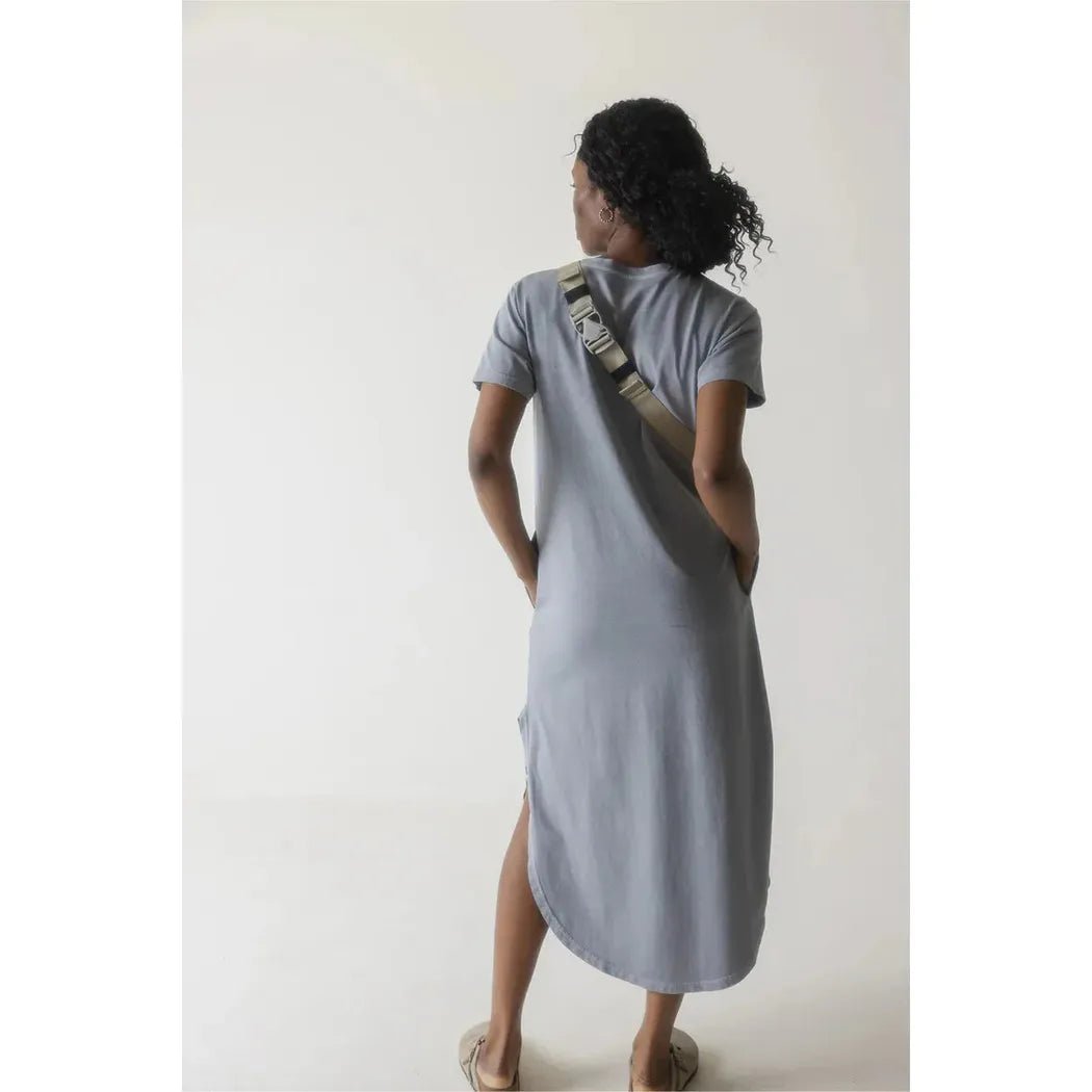 Back view of the Kavu Pint Size bag in Calm Palm worn by a model against a plain white background.