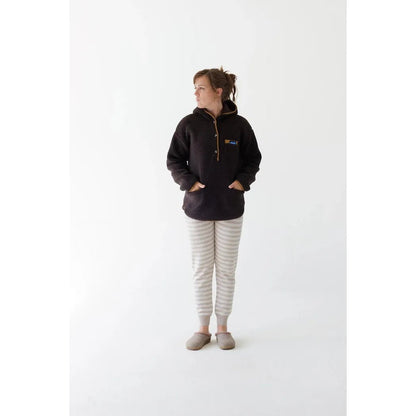 A woman wearing the Kavu Women's Roselake Coffee top stands against a white background.