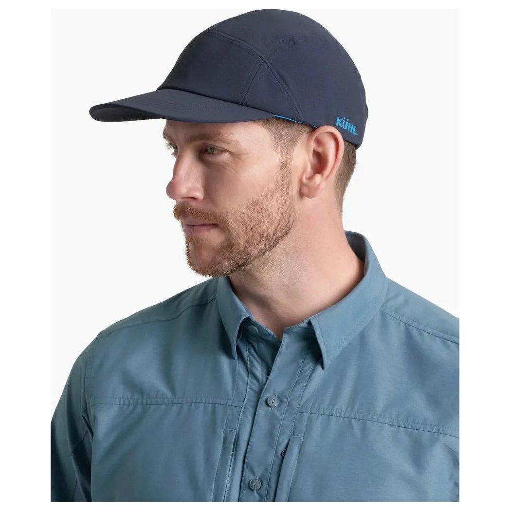 Side view of the Kuhl Breeze Cap in Pirate Blue on a model wearing a blue shirt against a white background.