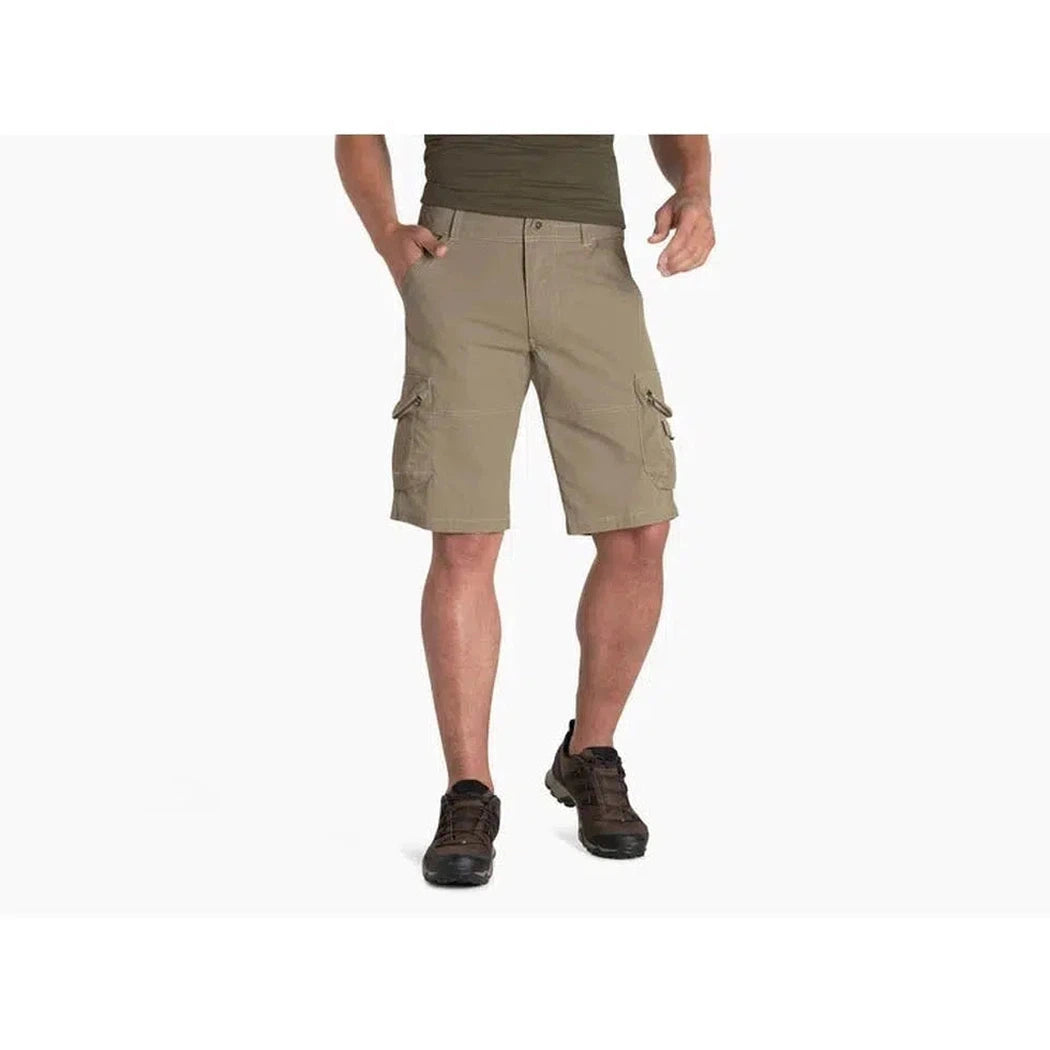 Side view of the Kuhl Men's Ambush Cargo shorts on a model wearing dark shoes against a white background.