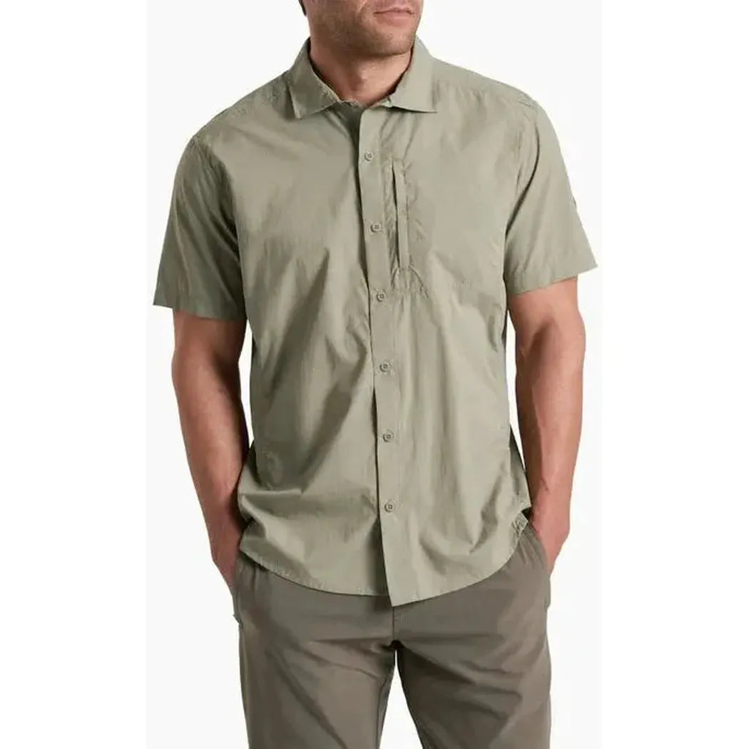 A front view of the Kuhl Men's Driftr Short Sleeve in Spanish Moss with hands in pockets against a white background.