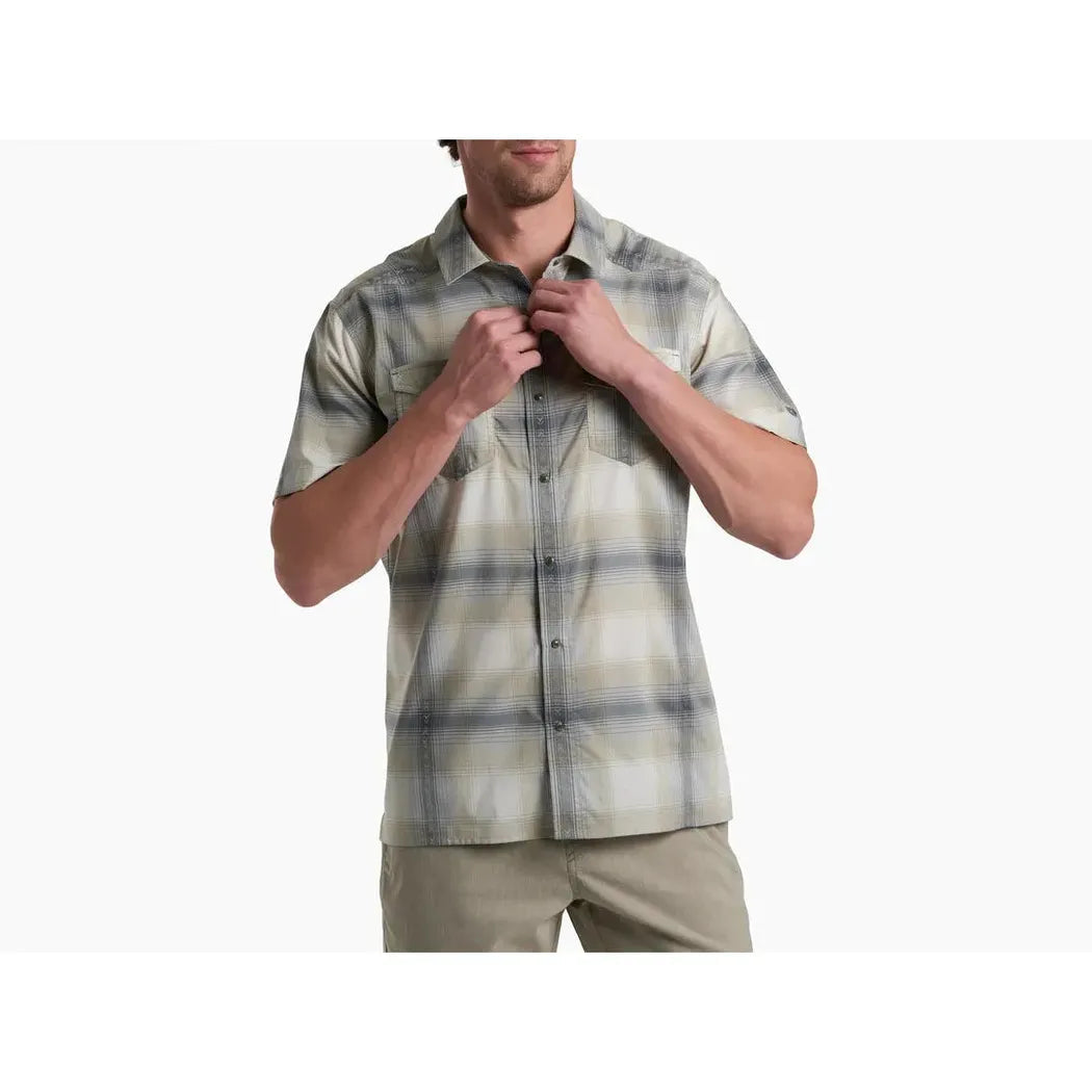 A front view of the Kuhl Men's Konquer Short Sleeve in Feather Grey on a model wearing khaki pants against a white background.