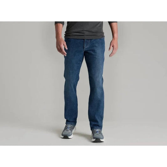A front view of the Kuhl Men's Kontrol Denim Klassik in Medium Wash on a model wearing gray sneakers against a plain background.