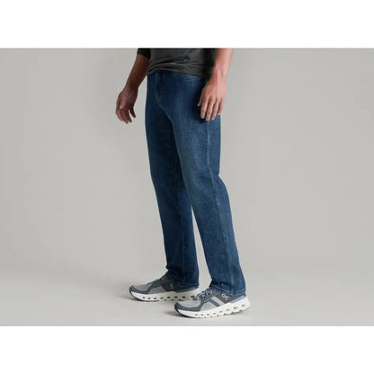 Side view of the Kuhl Men's Kontrol Denim Klassik in Medium Wash showing the straight leg fit against a light gray background.
