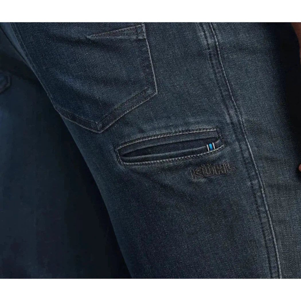 Side view of the Kuhl Men's Kuhl Denim in Midnight showing the zippered pocket and brand name on the denim.