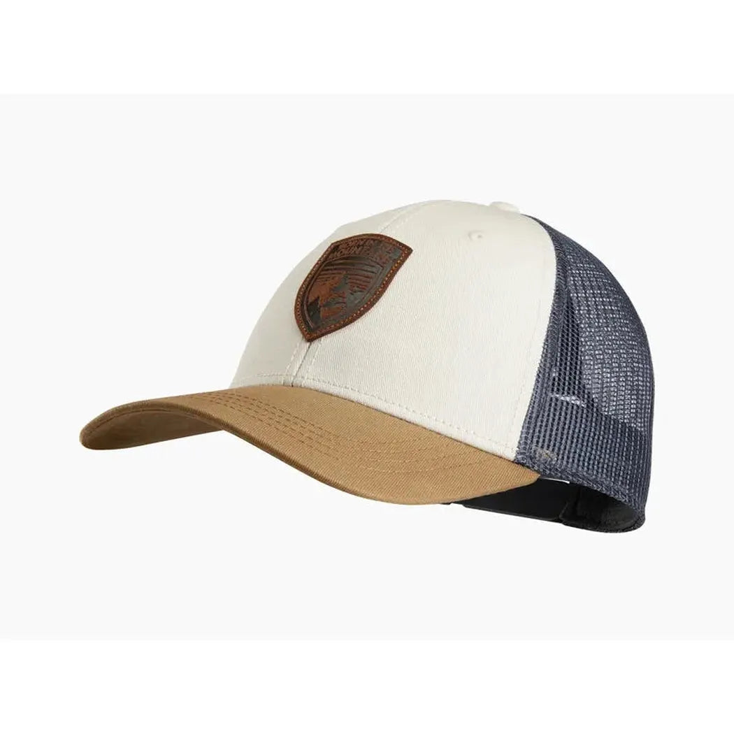 A front view of the Kuhl Rustik Born Trucker hat in Desert Oasis color with a brown leather patch and mesh back, set against a white background.
