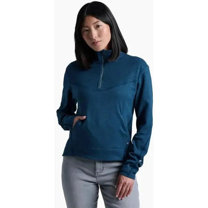 A front view of the Kuhl Women's Lola 1/2 Zip in Metal Blue on a model wearing light gray pants against a white background.