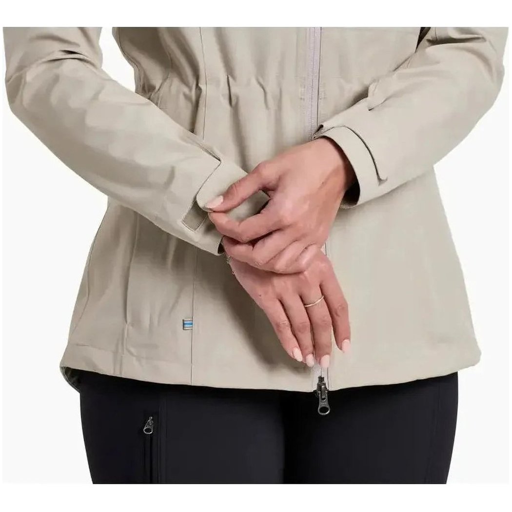 A close-up of the Kuhl Women's Stretch Voyagr Jacket in Silverstone, showing the model's hands and a zipper pull against a white background.