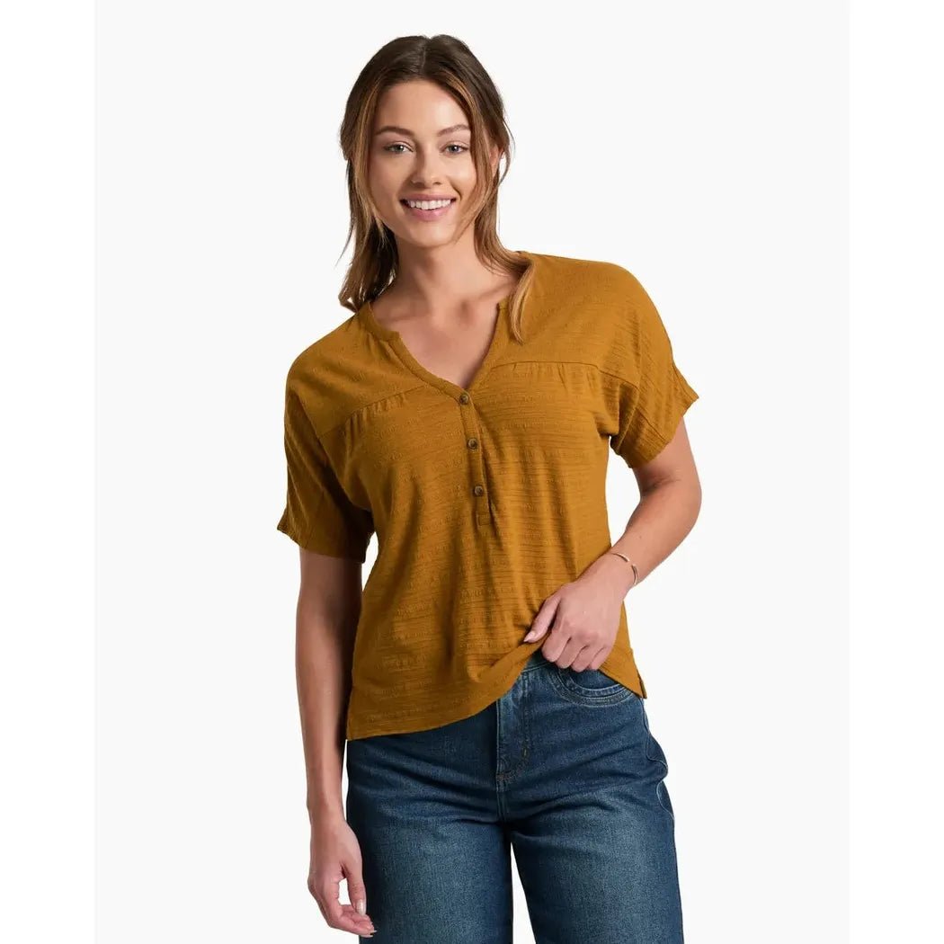 A model wearing the Kuhl Women's Willa Short Sleeve Bronze top stands against a plain white background.