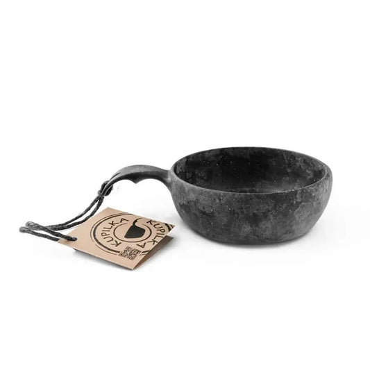 A black Kupilka 33 Junior Soup Bowl with a handle sits on a white background next to its tag.