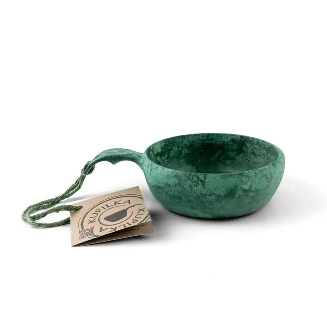 A black Kupilka 33 Junior Soup Bowl with a handle sits on a white background next to its tag.