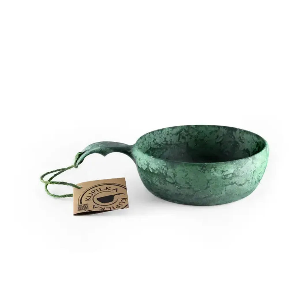 A black Kupilka 55 Soup Bowl with a handle sits on a white background next to a tag.