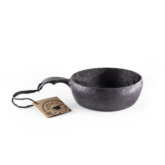 A black Kupilka 55 Soup Bowl with a handle sits on a white background next to a tag.