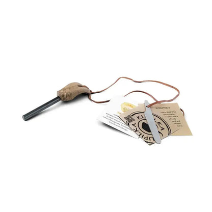 A black Kupilka Firesteel 8 with a brown handle and attached leather cord lies on a white background next to instruction cards.