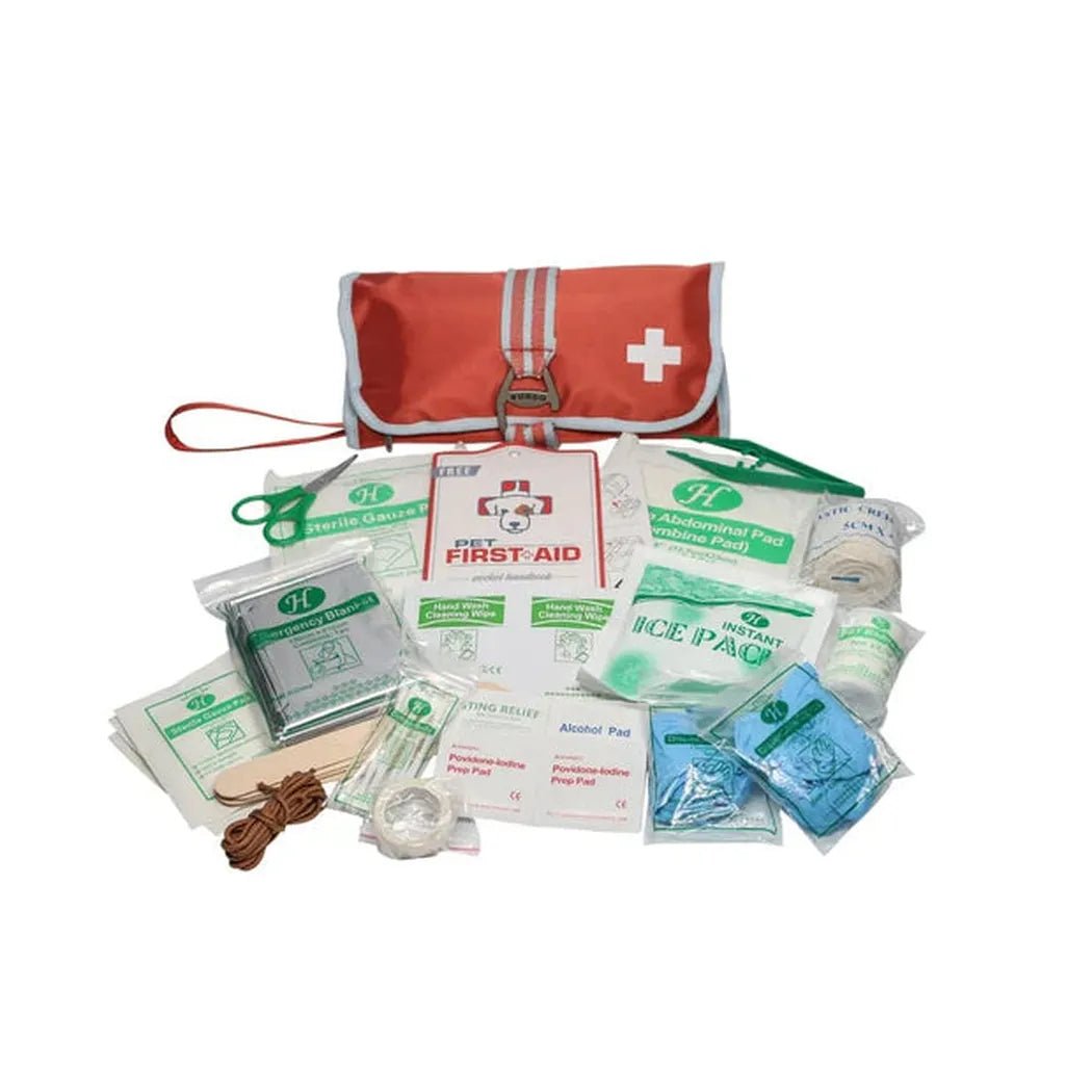 A top-down view of the Kurgo First Aid Kit in Paprika showing the red pouch with white cross and various first aid supplies spread out on a white background.
