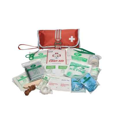 A top-down view of the Kurgo First Aid Kit in Paprika showing the red pouch with white cross and various first aid supplies spread out on a white background.