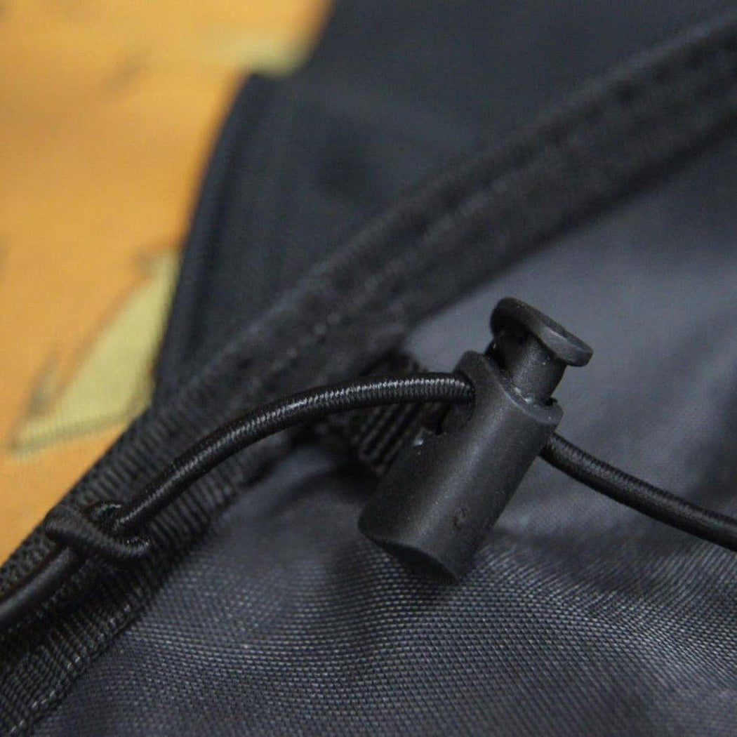A close-up of the Kurgo Wander Hammock in Charcoal showing the drawcord and plastic adjuster against a camouflage background.