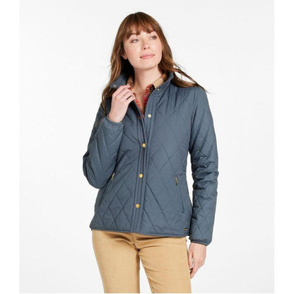 A woman wears the L.L.Bean Display Sample - Women's Bean Cozy Quilted Jacket in Rangeley Blue against a white background.