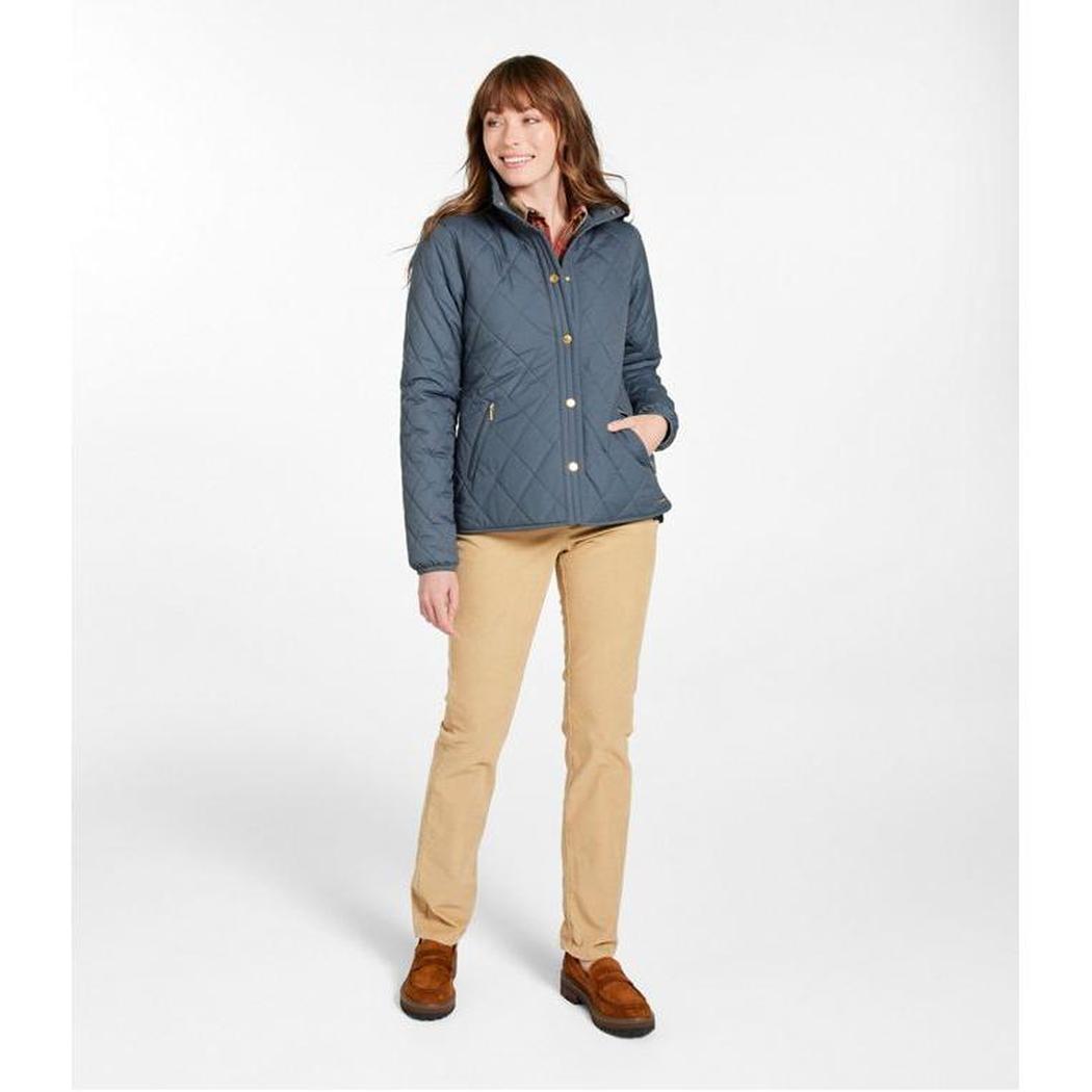 A woman wearing the L.L.Bean Display Sample - Women's Bean Cozy Quilted Jacket in Rangeley Blue stands against a white background.