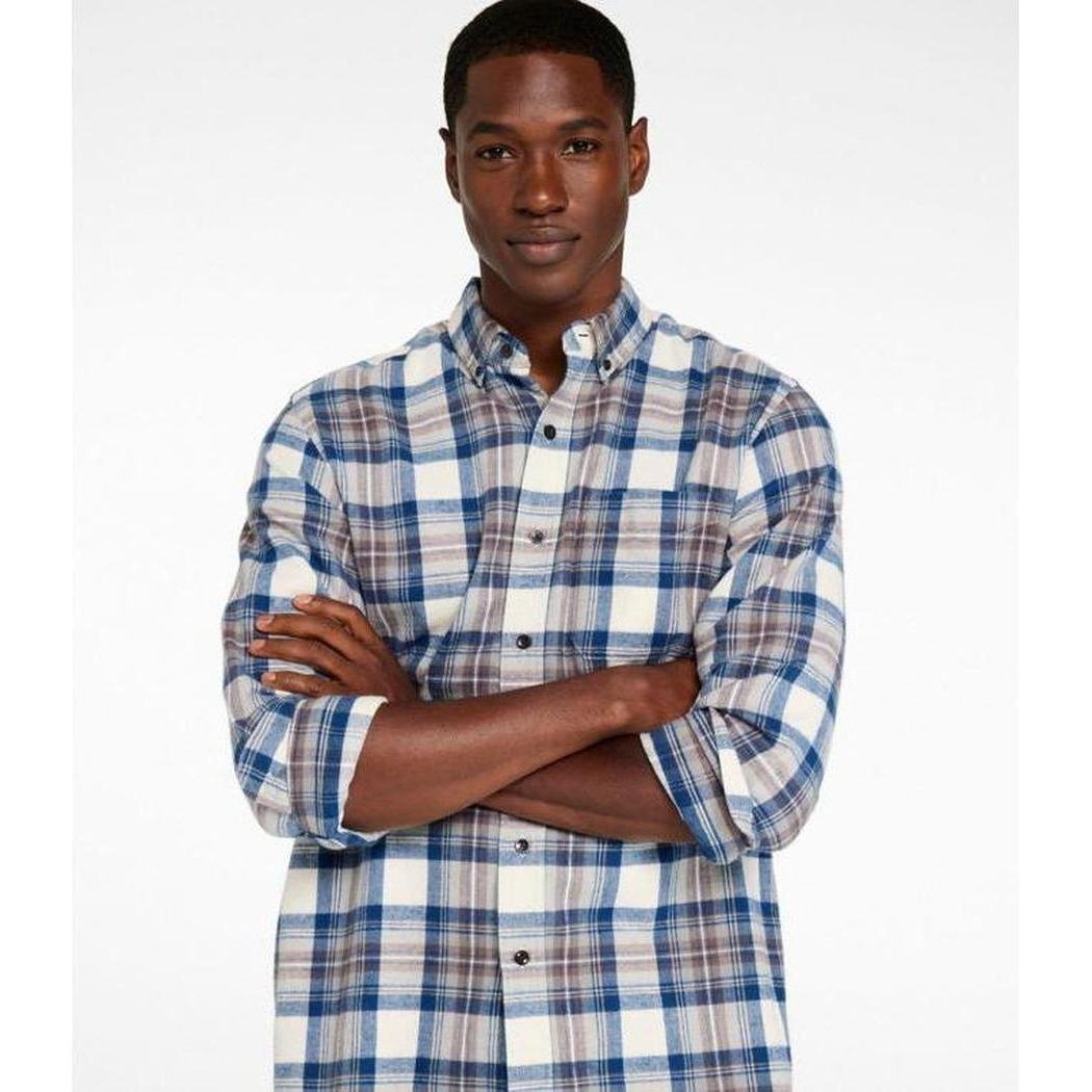 A model wearing the L.L.Bean Men's Long Sleeve Scotch Plaid Flannel Shirt in Indigo Tartan stands with arms crossed against a plain white background.