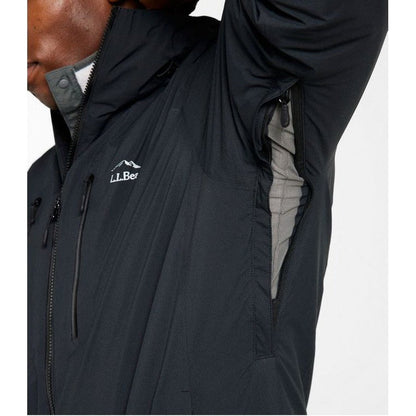 A close-up of a man wearing the L.L.Bean Men's Waterproof Primaloft Packaway Jacket in Black, showing the front zipper and side pocket with a light gray interior against a plain white background.