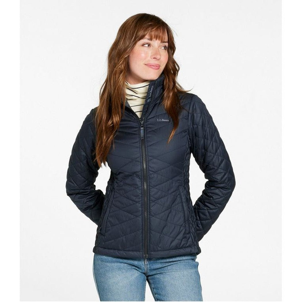 A woman in a Carbon Navy L.L.Bean Women's Regular Fleece Lined Primaloft Jacket stands with her hands in pockets against a white background.