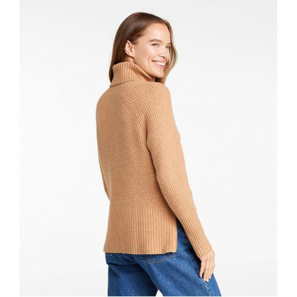 Side view of the L.L.Bean Women's SuperSoft Waffle Turtleneck Sweater in HoneyBrownHeath on a model wearing blue jeans against a white background.