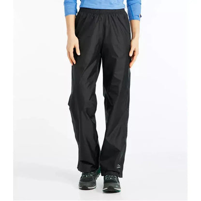 A front view of the L.L.Bean Women's Trail Model Rain Pants in Black on a model wearing black shoes against a white background.