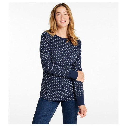 A woman wearing the L.L.Bean Women's Unshrinkable Mini-Waffle Long-Sleeve Crewneck Stripe Tee in Classic Navy Birdseye stands against a white background.