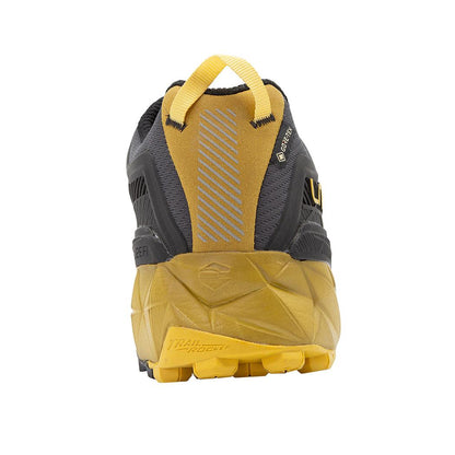 Back view of the La Sportiva Akyra II GTX in Carbon/Bamboo showing the yellow heel pull tab and rugged outsole against a white background.